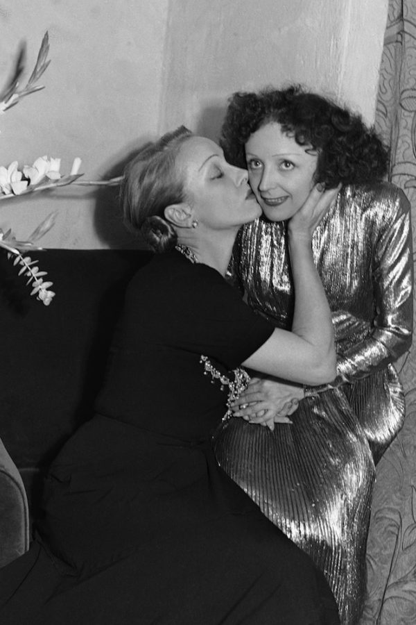 Marlene Dietrich, left, gives a congratulatory kiss to Edith Piaf after a performance at Playhouse Theater in New York, Oct. 30, 1947. (AP Photo/Matty Zimmerman)